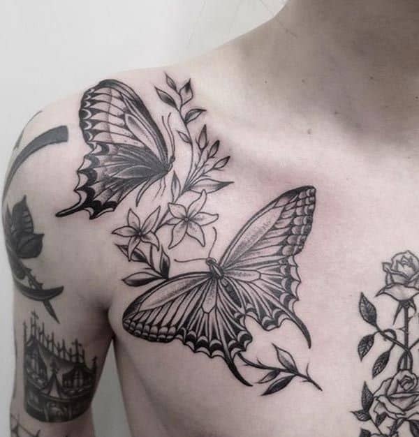 Elegant black and grey butterfly and floral tattoo on the chest and shoulder, featuring intricate shading and fine linework.