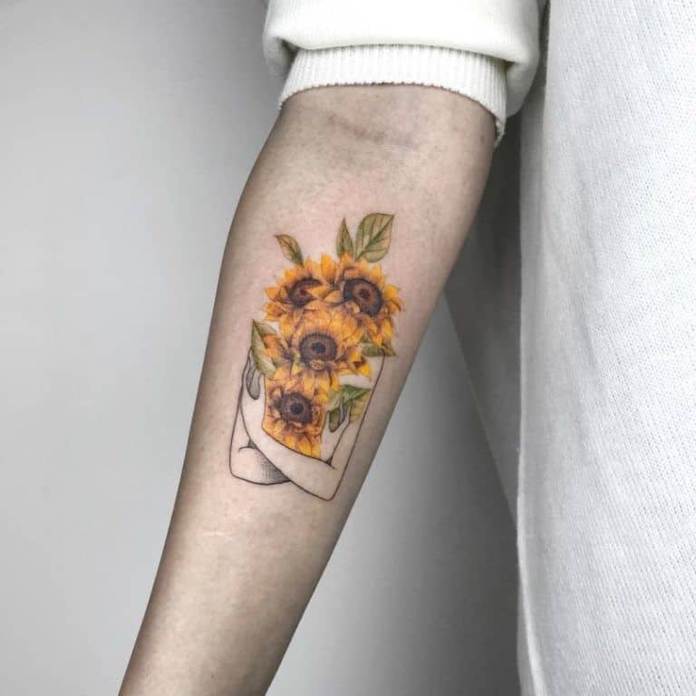 Artistic sunflower tattoo on forearm featuring a minimalistic outlined figure embracing a bouquet of vibrant yellow sunflowers with green leaves.