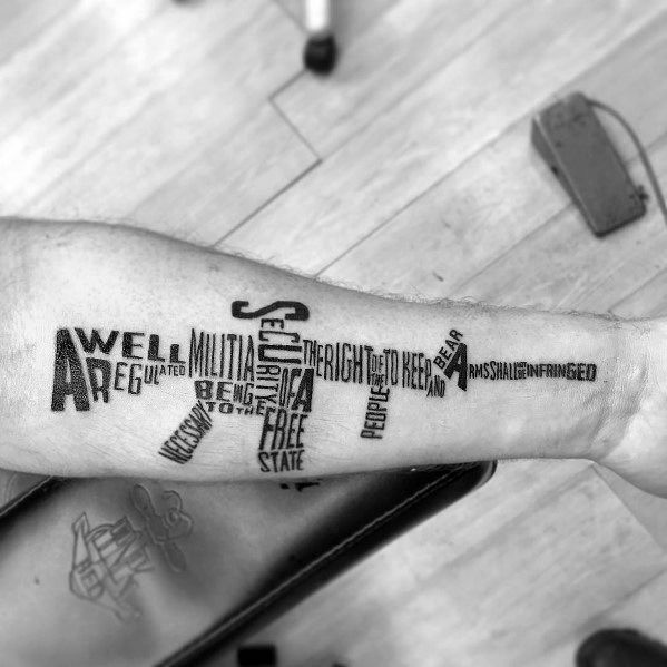 Second Amendment text tattoo arranged in the shape of a rifle on the forearm, symbolizing gun rights, freedom, and constitutional protection.