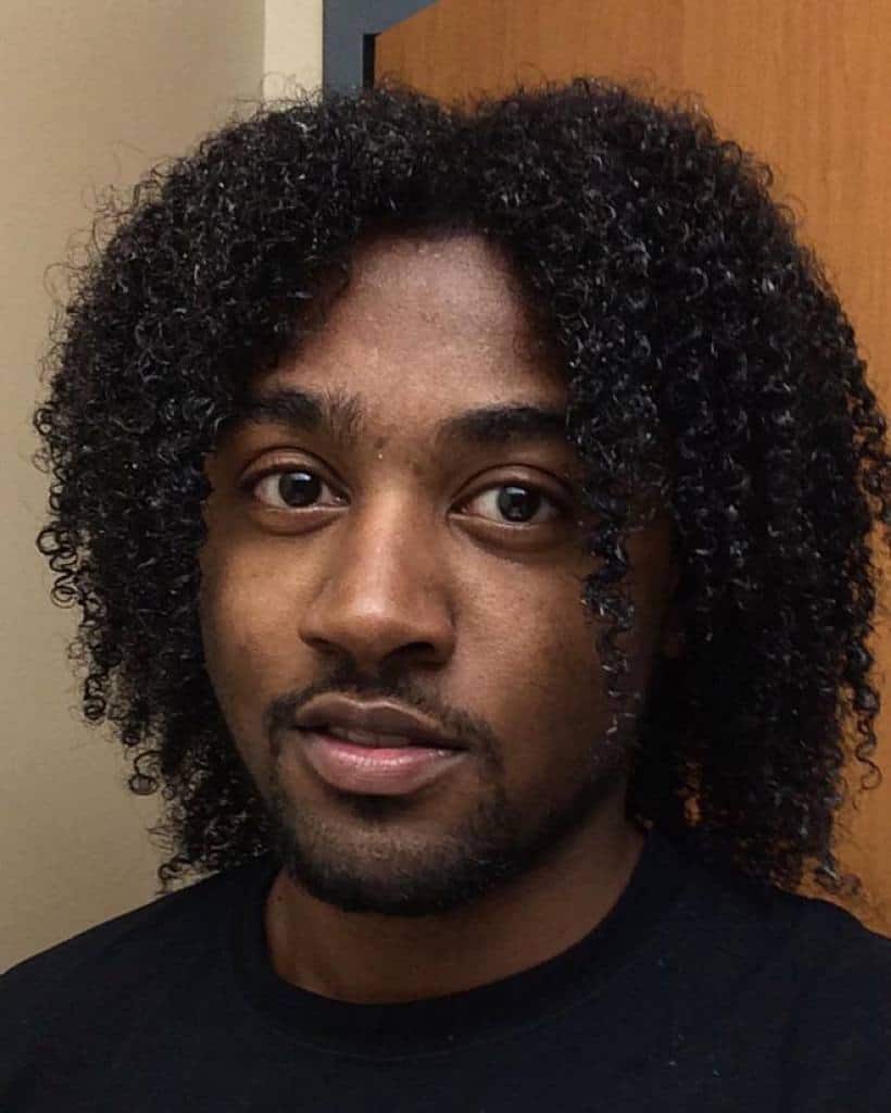 A man with type 3C hair wearing a bob with medium-length tresses. A great look if you want to frame your facial features