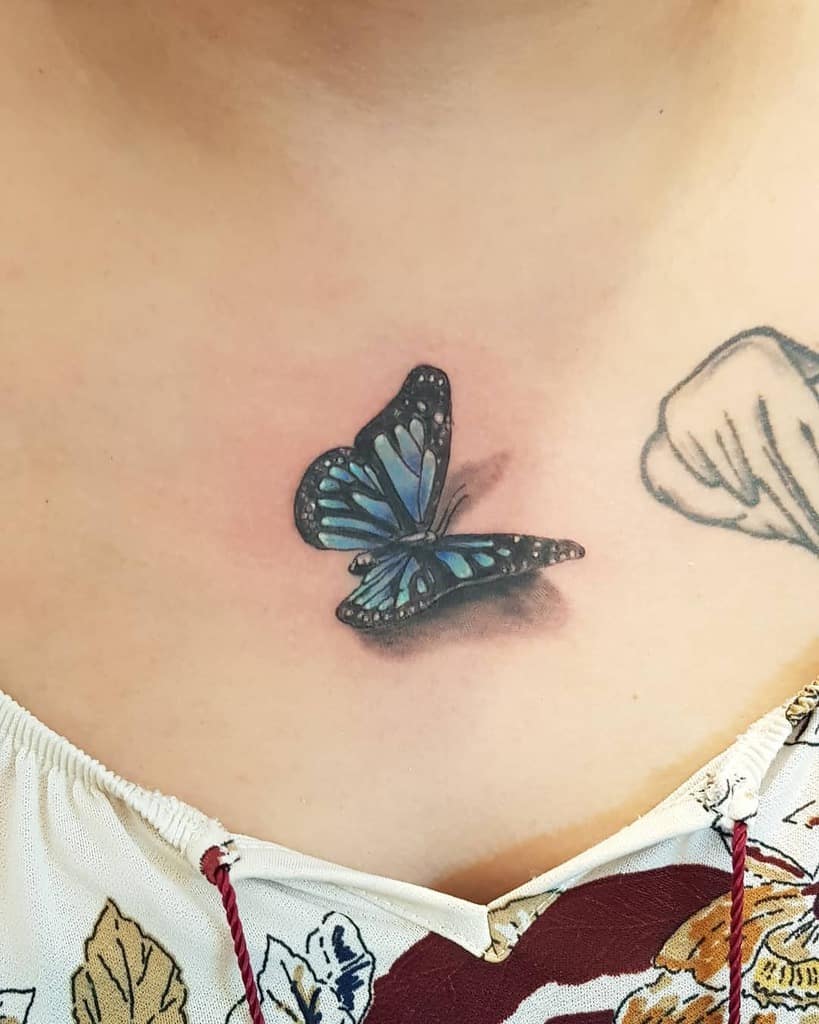 A realistic black and blue butterfly tattoo