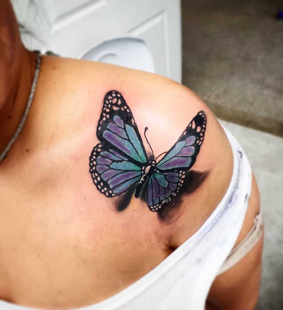 Stunning purple and blue butterfly tattoo on the shoulder with a bold 3D shadow effect, creating a lifelike and elegant design.