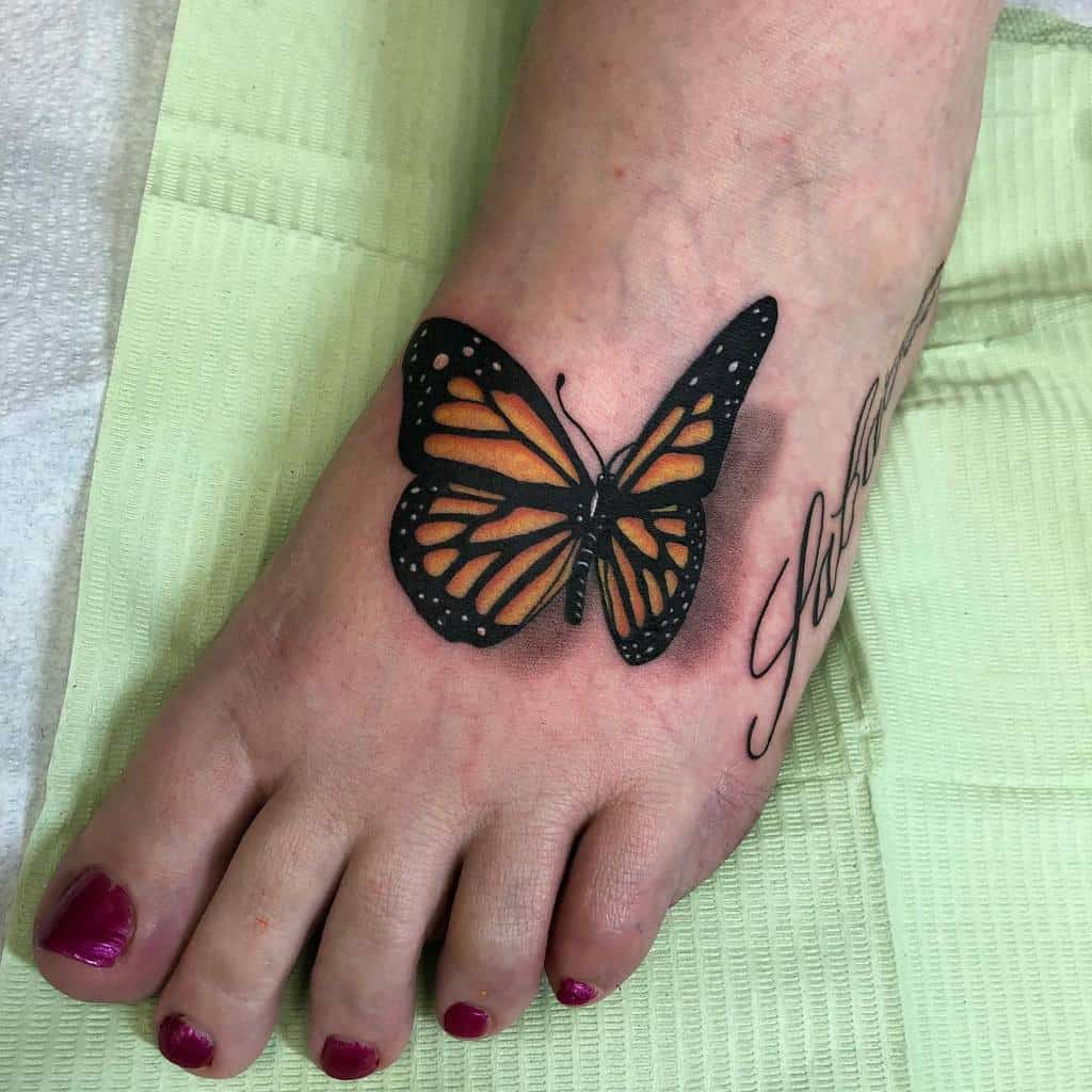 Foot with a vibrant butterfly tattoo and script
