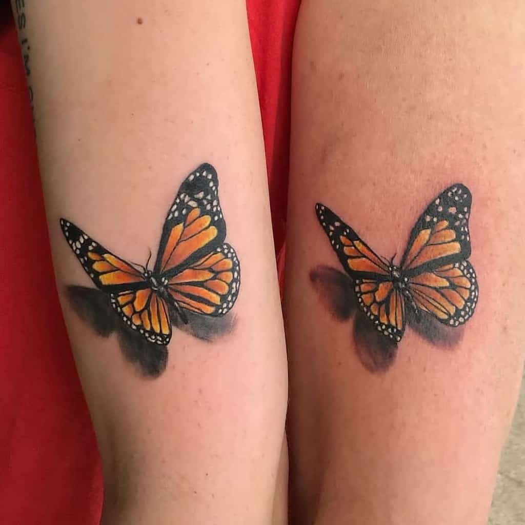 Two arms with matching realistic monarch butterfly tattoos with shadow effects