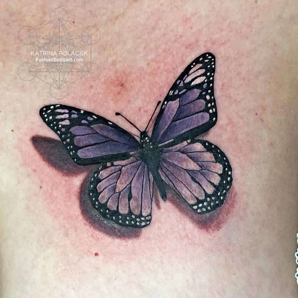 Tattoo of a butterfly with purple wings and detailed patterns on light skin