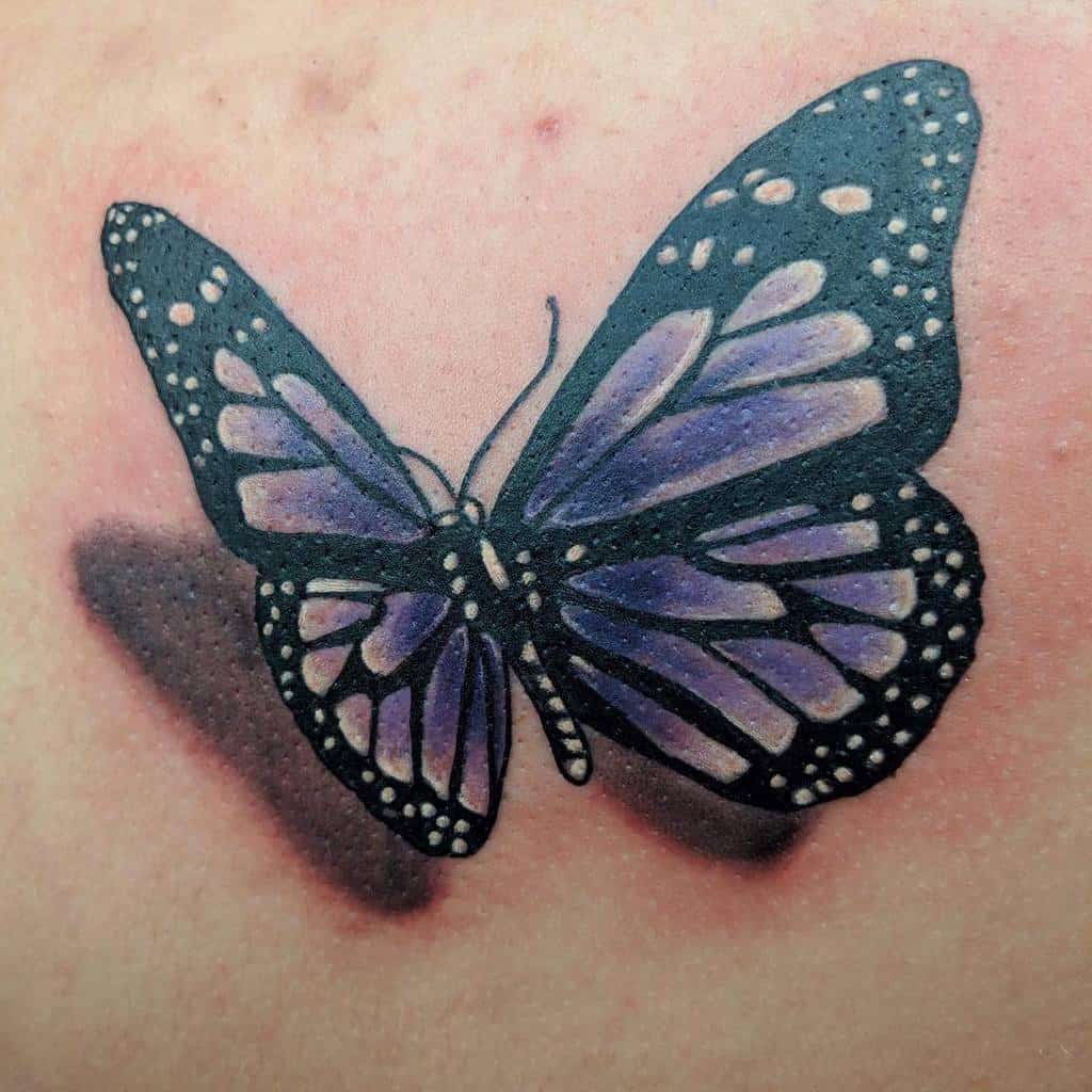 Tattoo of a black and purple butterfly with white spots