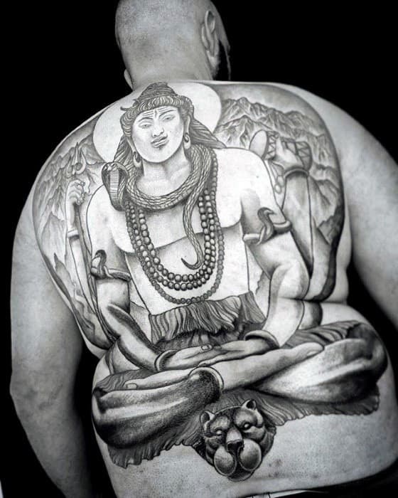 Massive back tattoo of Lord Shiva in a meditative pose with detailed mountain scenery, seated on a lion’s head and holding a trident.