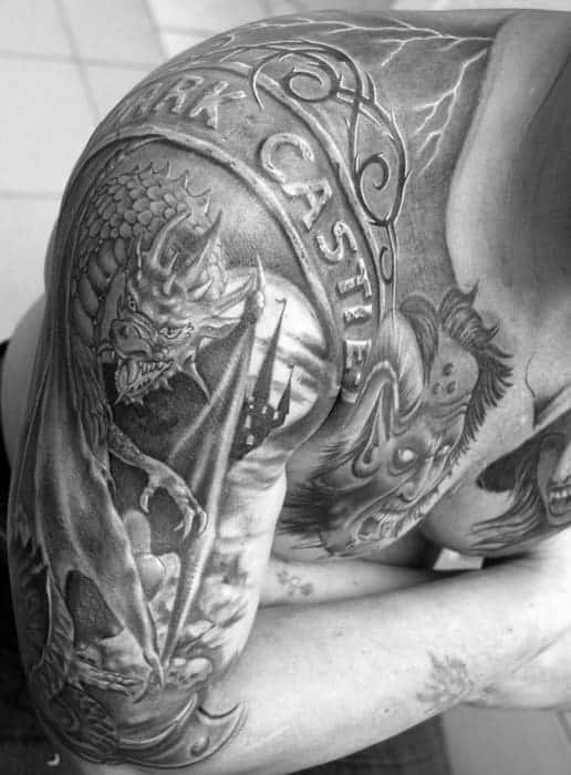 A detailed black-and-white dragon tattoo with "DARK CASTLE" on an arm and chest