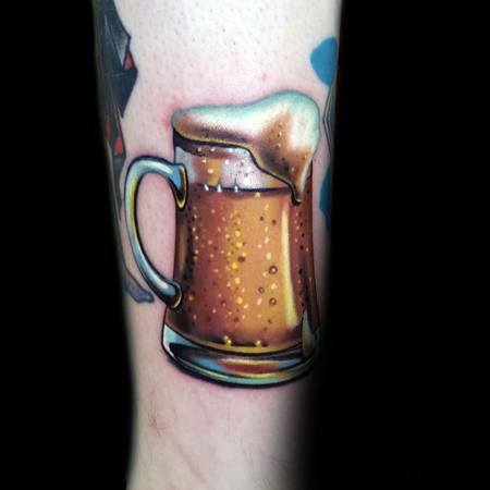 Colorful and realistic tattoo of a frothy beer mug with visible bubbles and foam, capturing a refreshing and vibrant look on the forearm.