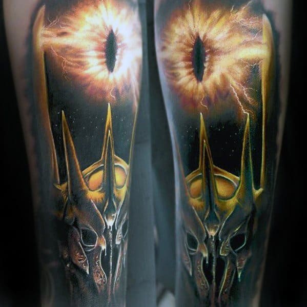 A tattoo of the Eye of Sauron ablaze with intensity beneath a formidable spiky, dark helmet