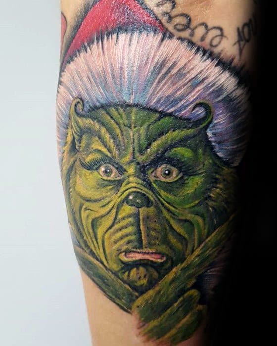 Grinch character with a red Santa hat, detailed with vibrant green and red hues, creating a playful and expressive tattoo design.