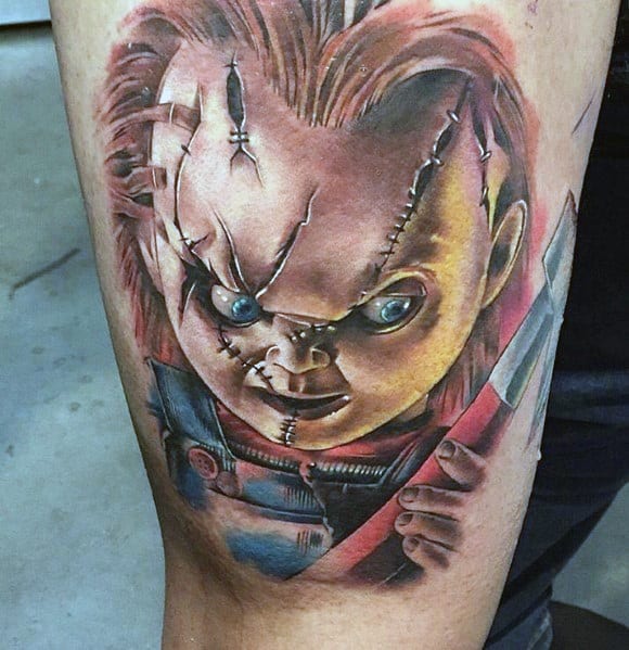 Chucky horror tattoo with realistic details, showing the iconic stitched face and menacing expression while holding a knife.