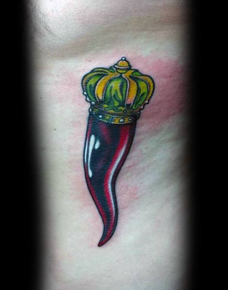 Bold Italian horn tattoo with a golden crown, symbolizing luck and protection, inked in a sleek black and red gradient style.
