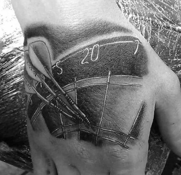 Dartboard tattoo on hand with three darts hitting the bullseye, featuring numbers 5, 20, and 1 in bold shading.
