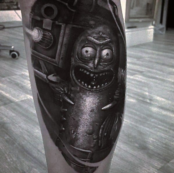Black and grey Pickle Rick tattoo with a dark, detailed design, featuring sharp shading and a menacing expression on the leg.