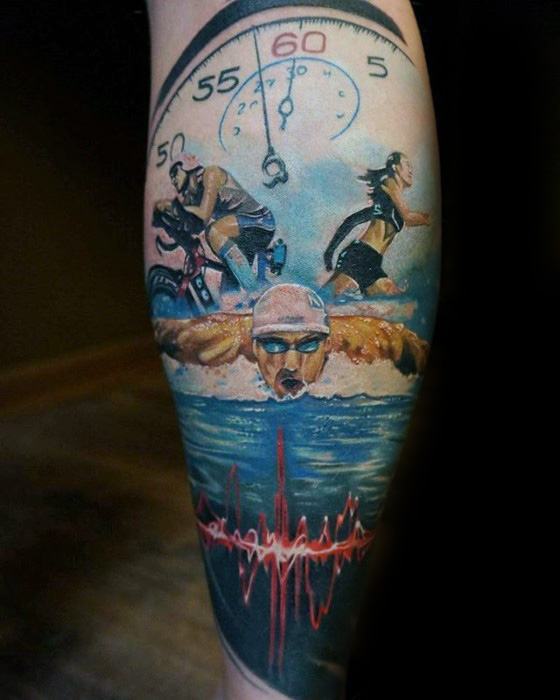 Realistic Ironman triathlon tattoo showing a stopwatch above dynamic swim, bike, and run scenes, with a red heartbeat line over dark water.