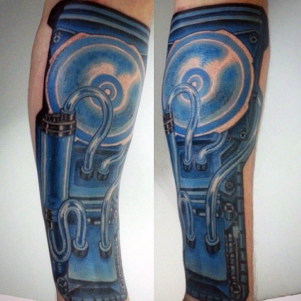 Blue-toned biomechanical tattoo on a man’s forearm resembling internal computer hardware with wires and metallic components.