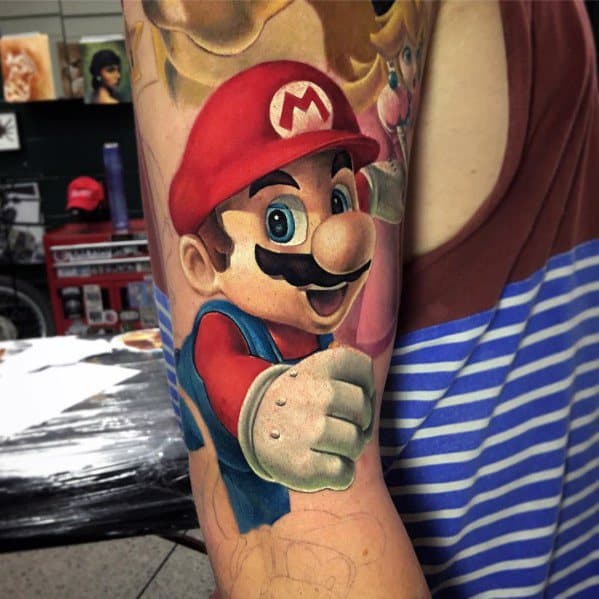 Colorful tattoo of Mario on a man's arm, featuring bold shading and dynamic detail in a classic video game-inspired design.