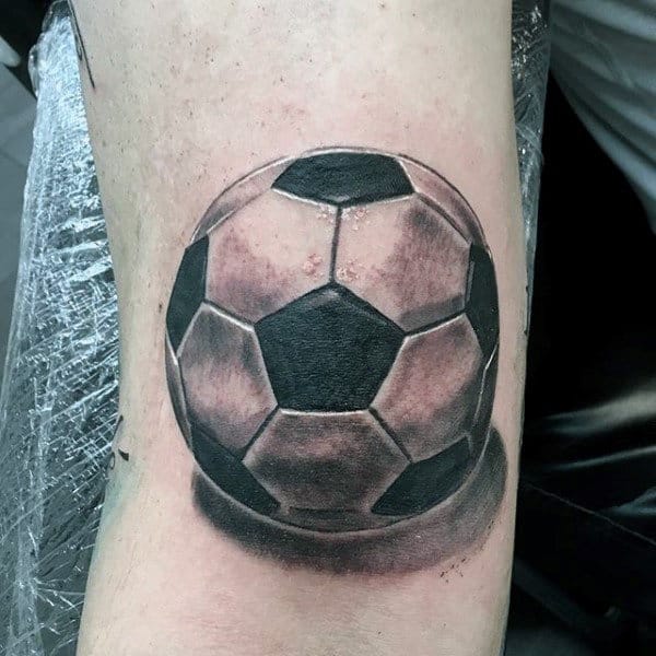 Soccer ball tattoo design featuring 3D shading on man's arm