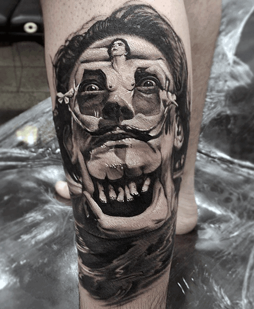 Surreal black and grey tattoo of a distorted male face with exaggerated teeth, integrated with a floating human figure across the eyes.