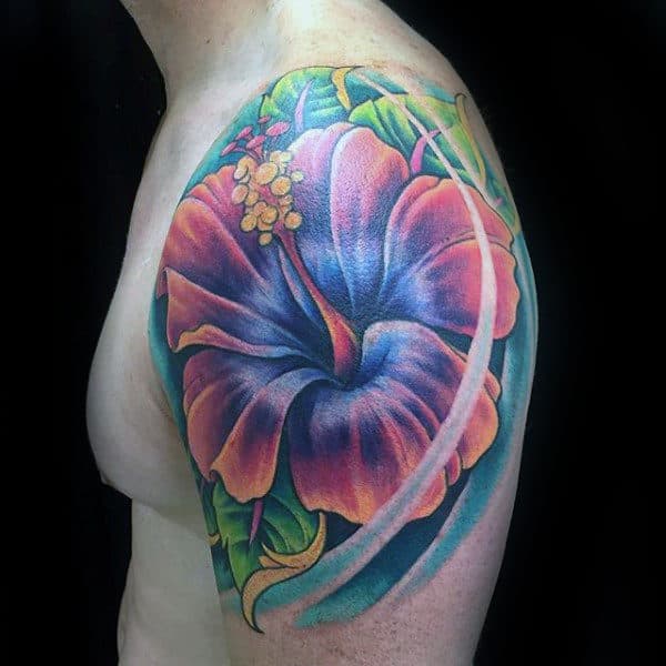 Colorful hibiscus tattoo on upper arm with vibrant pink, purple, and green hues
