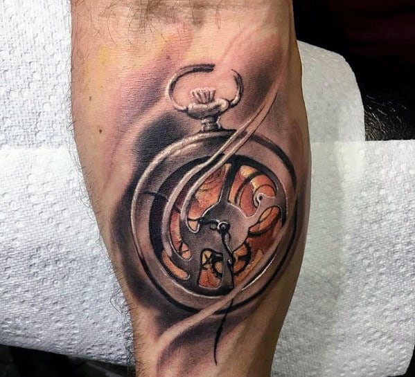 Tattoo of a pocket watch with visible gears, intricate shading, and a mix of warm colors, displayed on a forearm