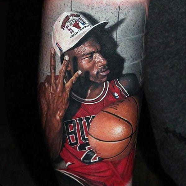 Hyper-realistic color tattoo of a basketball player in a Bulls jersey holding a ball and wearing a championship hat, showing three fingers in victory.