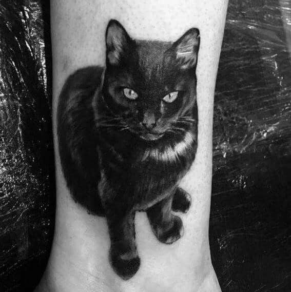 Realistic black cat tattoo on the lower leg, featuring fine shading and lifelike fur texture for a striking and detailed design.