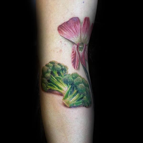 Realistic broccoli and flower tattoo on the forearm, blending nature-inspired elements with vibrant colors for a unique design.