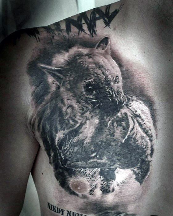 Realistic chest tattoo of a hyena holding its prey, rendered in black and grey with intense shading and lifelike texture.