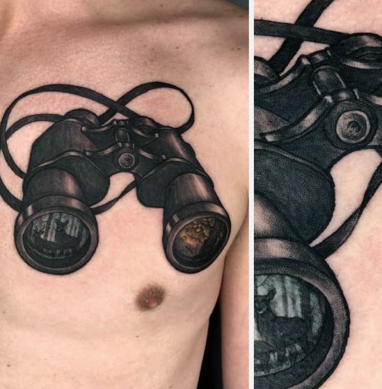 Realistic binoculars tattoo on chest with detailed reflections in lenses, creating a 3D illusion of looking into distant scenes.
