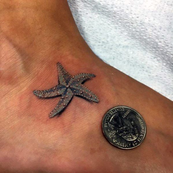Tiny realistic starfish tattoo on the foot, detailed with texture and shading, shown next to a coin for size comparison.