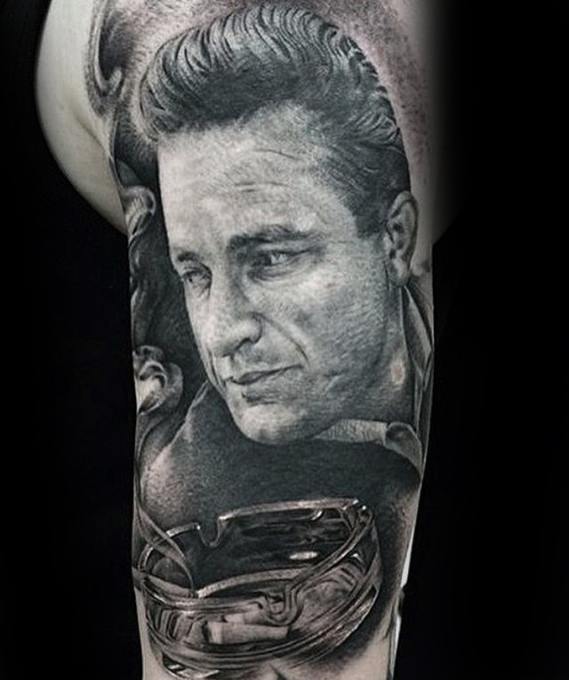 Tattoo of Johnny Cash's face with an ashtray and burning cigarette on an arm