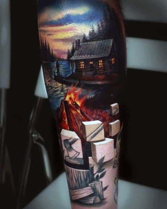 Cabin by a lake tattoo with sunset sky, log fire, and chopped wood, blending realism and outdoor wilderness themes.