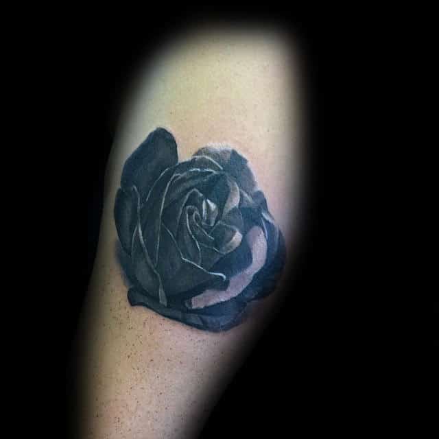 Black and gray rose tattoo on a forearm