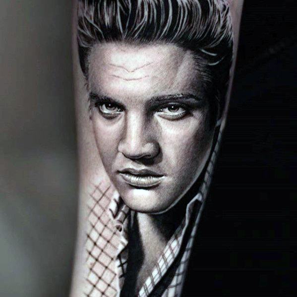 Realistic black and grey Elvis Presley tattoo on forearm, featuring his iconic hairstyle and intense expression.