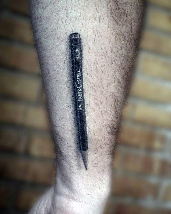 A stunning tattoo of a realistic pencil graces a person's forearm, standing out against the textured backdrop of a brick wall
