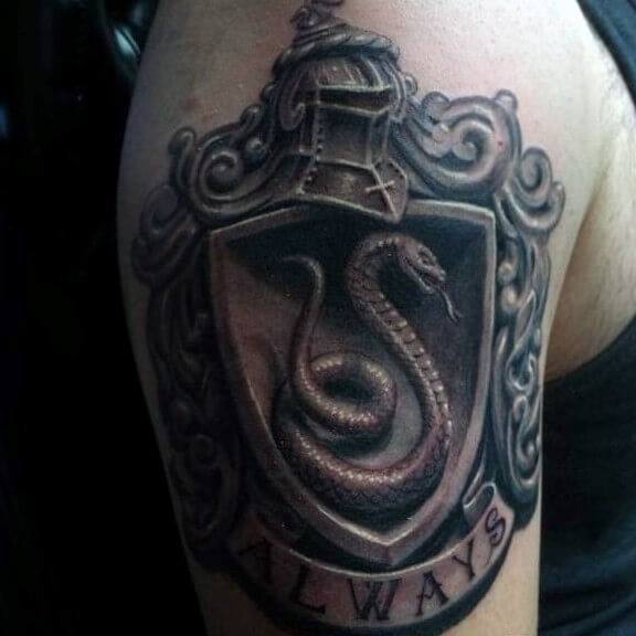 Dark, detailed tattoo of a shield with a coiled snake, ornate framing, a knight's helmet on top, and the word ALWAYS inscribed below.