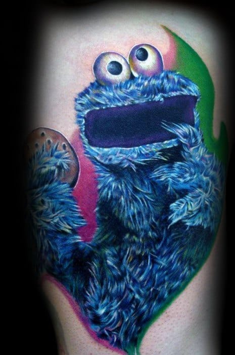 Vivid Cookie Monster tattoo with bright blue fur, holding a cookie, set against a bold pink and green background design.