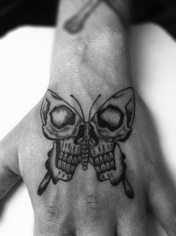 Bold black and grey skull butterfly tattoo on the hand, blending macabre and nature-inspired elements for a striking design.