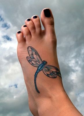 Realistic blue dragonfly tattoo on the top of the foot, featuring delicate wing details and fine shading for a lifelike effect.