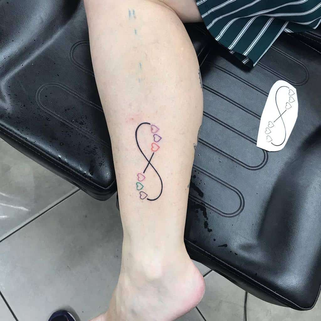 A delicate infinity tattoo with heart-shaped accents, adding a soft, colorful touch to symbolize love and eternity.