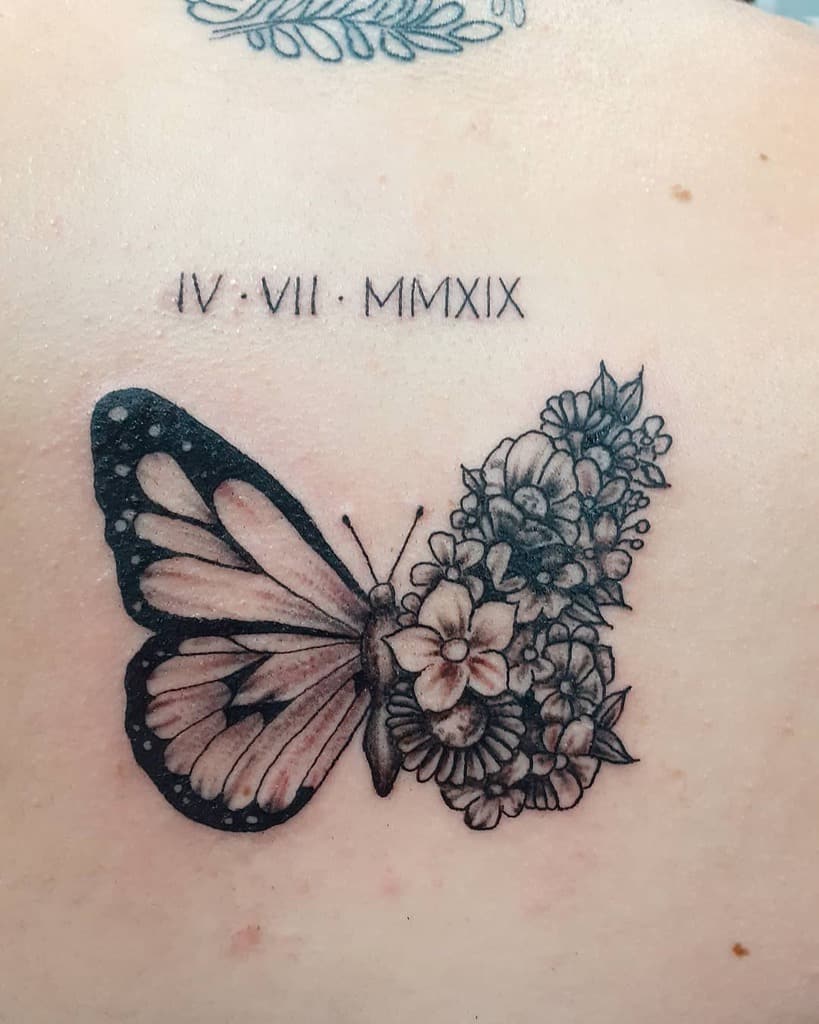 Elegant black and grey butterfly tattoo with one wing composed of intricate flowers, paired with a Roman numeral date above for a meaningful design.