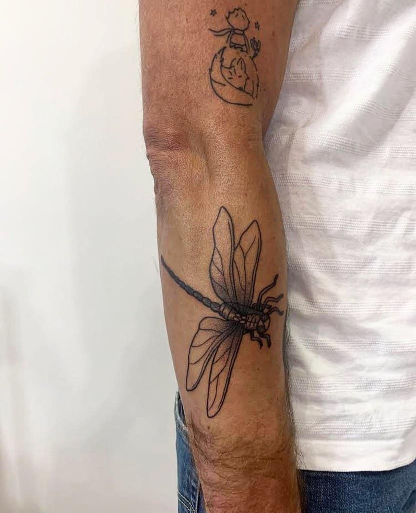 Minimalist dragonfly tattoo on the forearm, featuring fine linework and delicate wing details for a sleek and elegant design.
