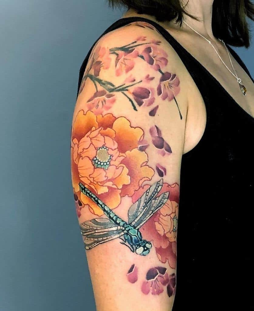 Vibrant full-sleeve tattoo featuring a detailed blue dragonfly, blooming orange peonies, and delicate pink cherry blossoms.