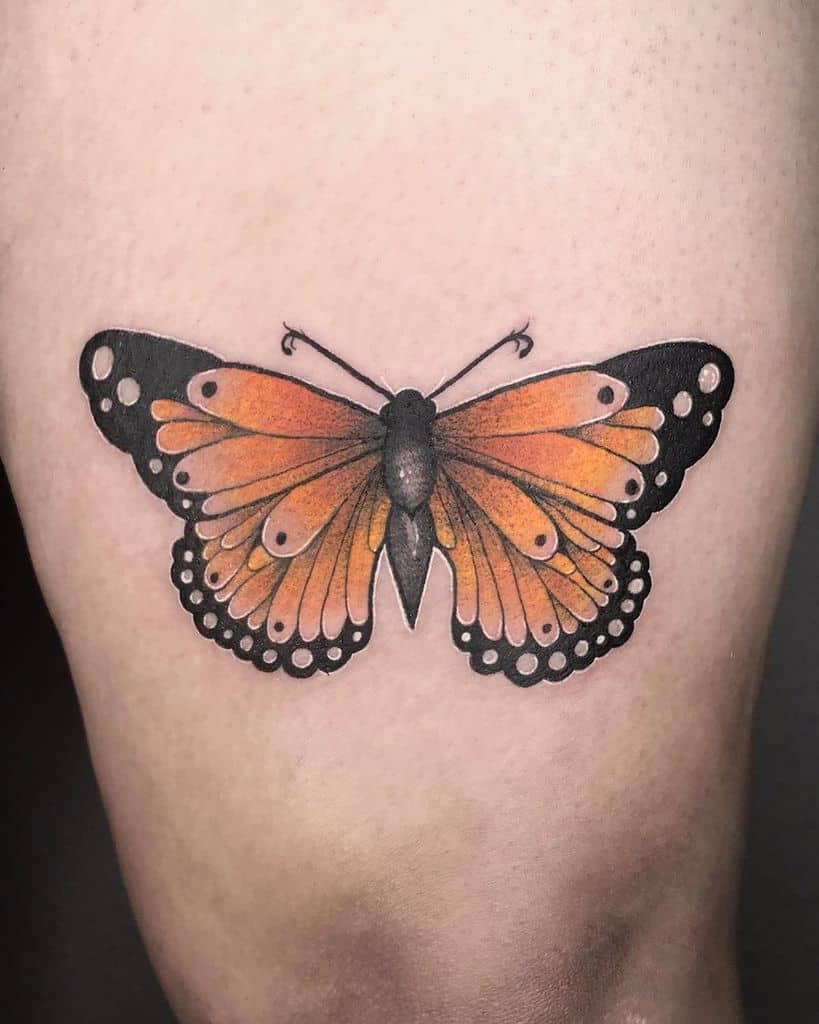 Realistic orange and black butterfly tattoo with intricate shading, creating a bold and vibrant design on the skin.