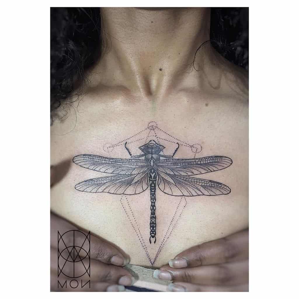 Intricate geometric dragonfly tattoo on the sternum, featuring fine linework, delicate dot shading, and symmetrical patterns for an elegant look.