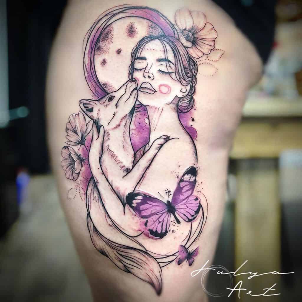 Artistic tattoo on the thigh featuring a woman embracing a fox, with a purple butterfly and floral details in a dreamy, ethereal style.