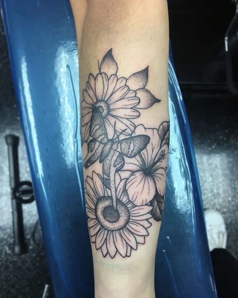 Beautiful black and grey floral tattoo with a butterfly, featuring intricate shading and fine details for an elegant forearm design.