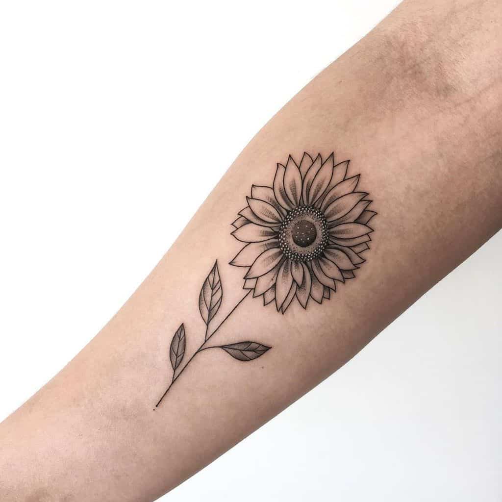 Tattoo of a sunflower with leaves on an inner forearm